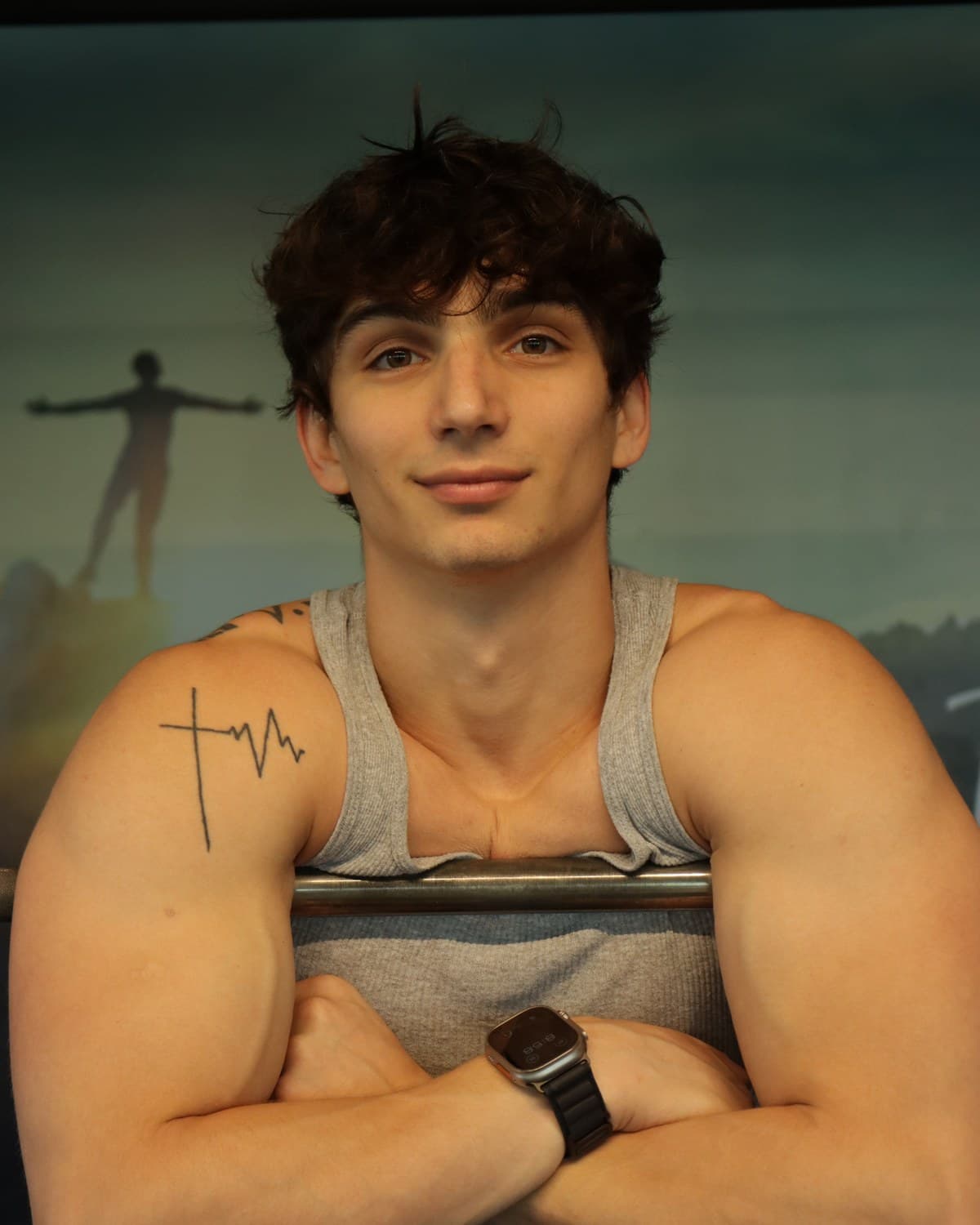 Kris Oddo in the gym with his arms crossed, looking toward the camera